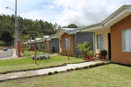 A row of houses with grass and trees

Description automatically generated